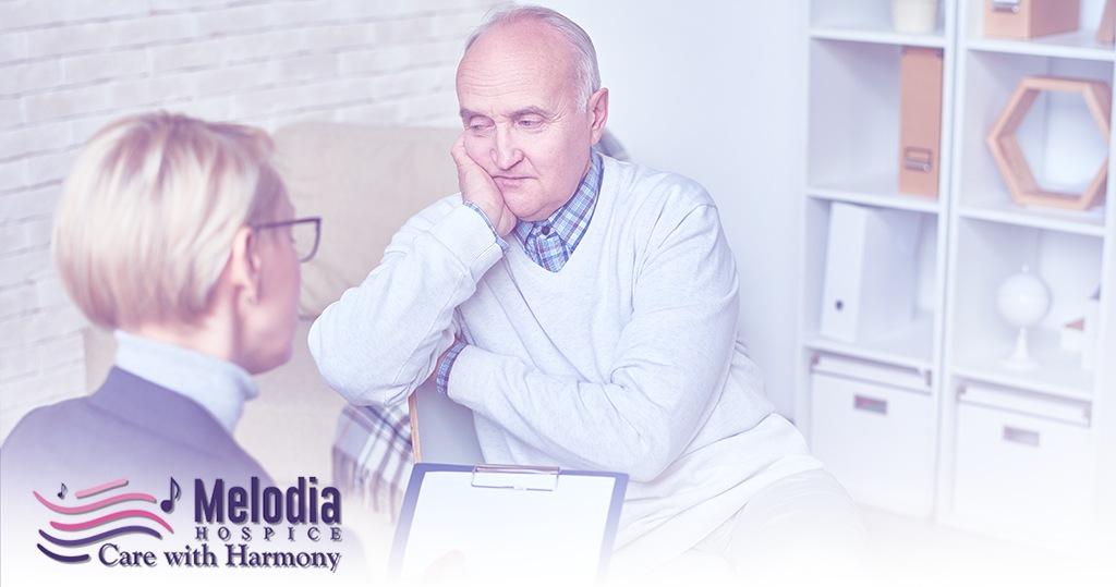 Elderly male patient consulting with female doctor, representing grief therapy and counseling